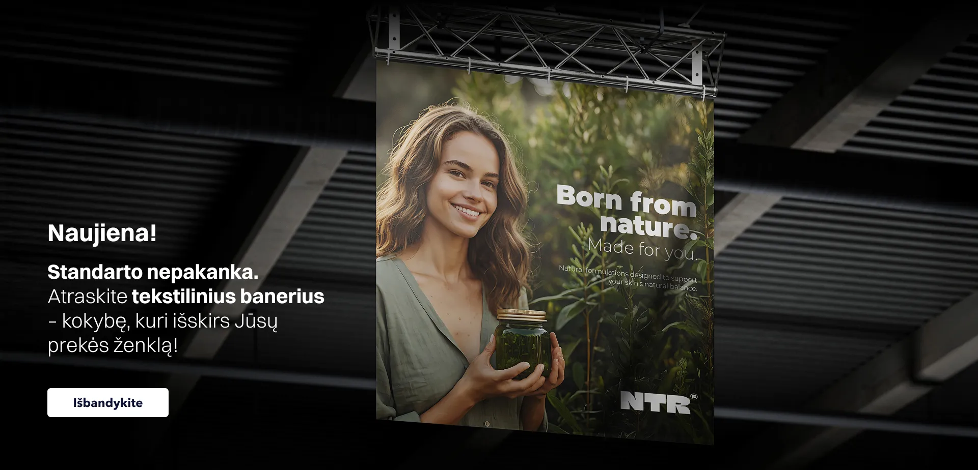 Baneris svetainei, reklamuojantis tekstilinius banerius su tekstu „Naujiena! Atraskite tekstilinius banerius – kokybę, kuri išskirs Jūsų prekės ženklą”